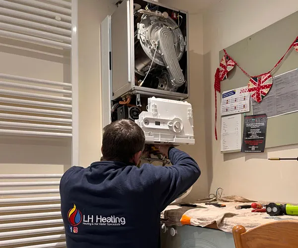 LH Heating engineer repairing a boiler inside a Hereford property