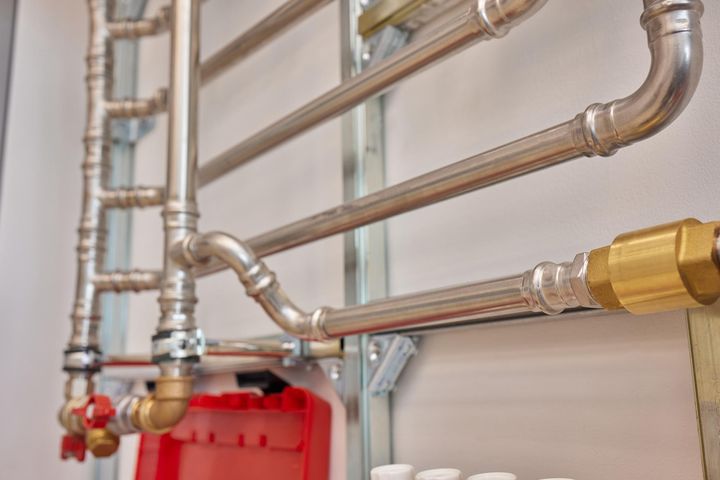 Plumber tightening fittings under kitchen sink in Knighton household